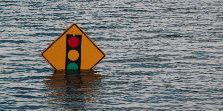 Road sign partially submerged in flood waters
