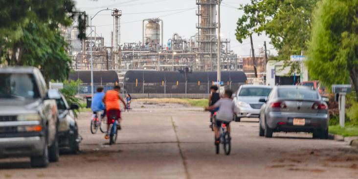 Kids bike in the streets of their Baytown, Texas neighborhood near oil and gas infrastructure.